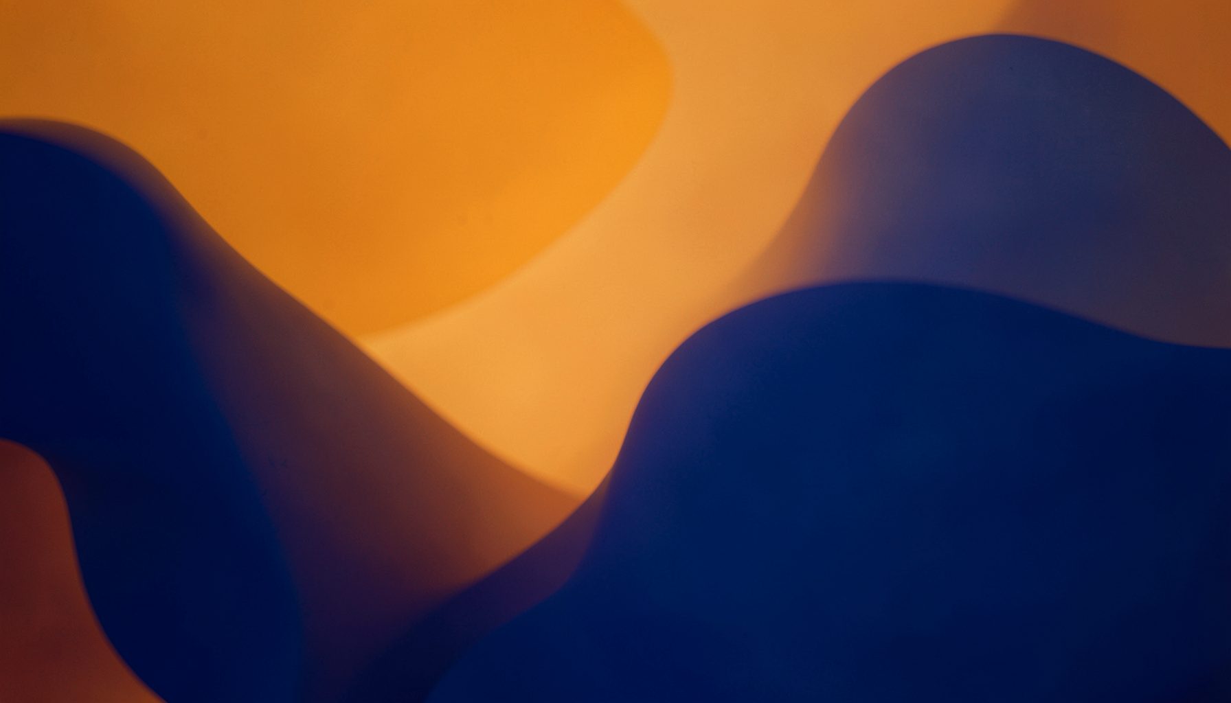 Warm amber and deep blue abstract composition with soft rounded shapes, evoking the energy of live music and audio playback